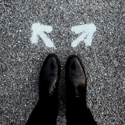 Feet with arrows pointing in different directions indicating a choice Photo by Jon Tyson on Unsplash
