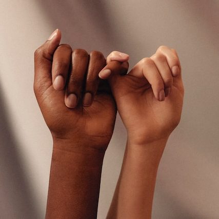 Women's hands linking pinkies Photo by Jon Tyson on Unsplash
