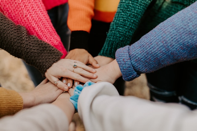group of hands on top of each other in a circle Photo by Hannah Busing on Unsplash