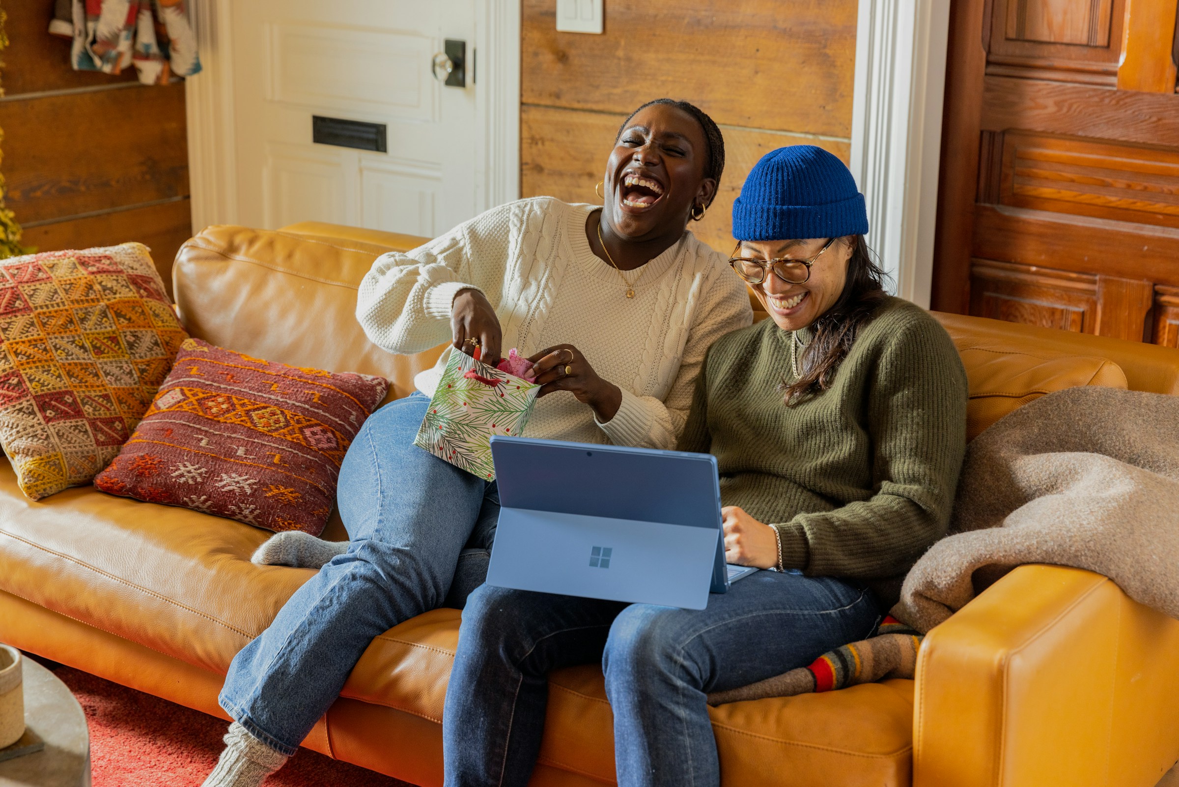 People sitting on a couch with a laptop photo Photo by Surface on Unsplash
