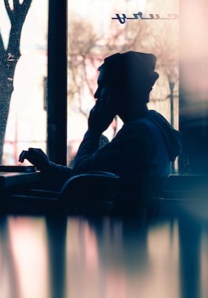 Silhouette of a person sitting in front of a laptop Photo by Hannah Wei on Unsplash